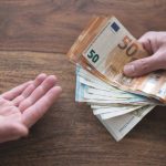 hand of one person handing over cash to another